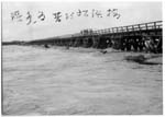 増水時の松浜橋を渡る人々